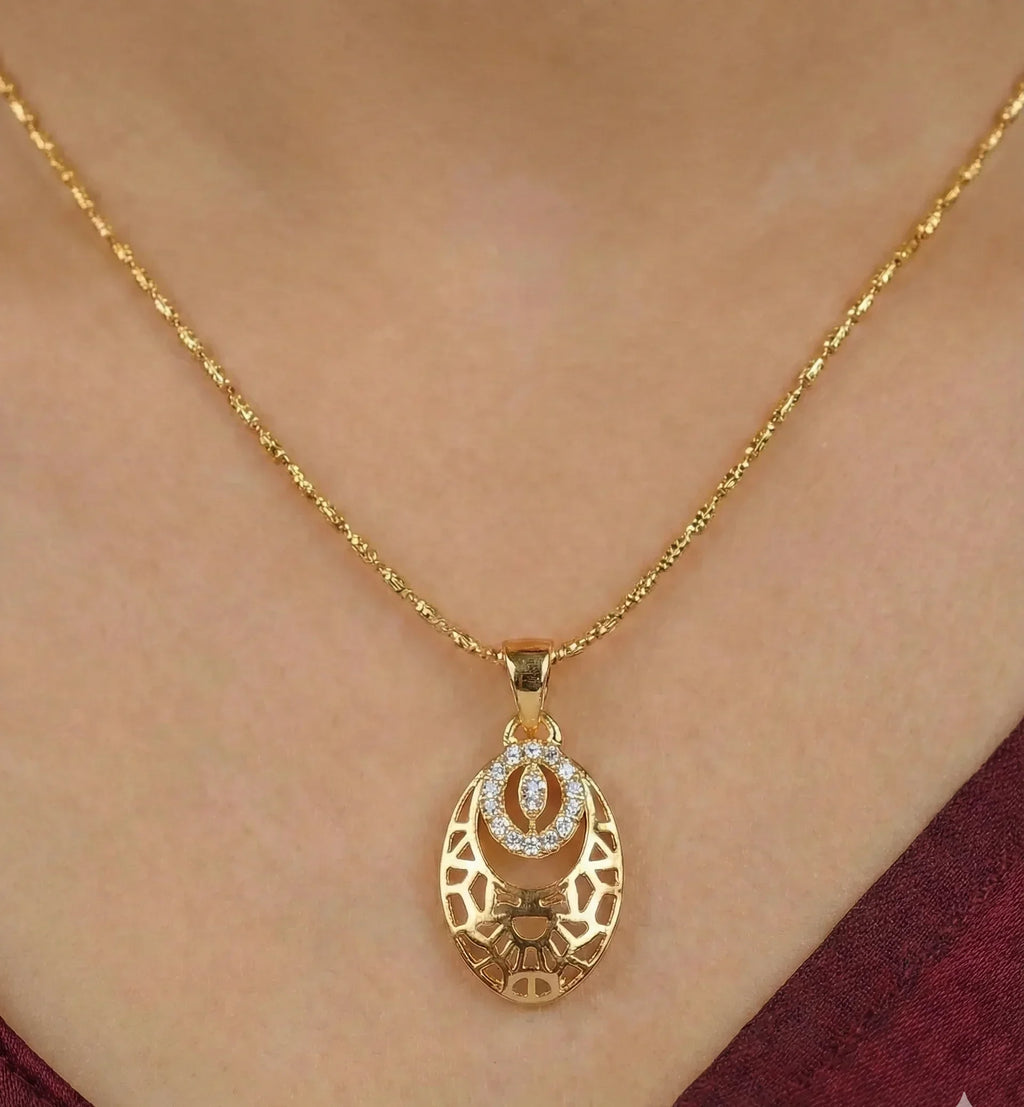 Gold necklace with a pendant on a person wearing a burgundy top.