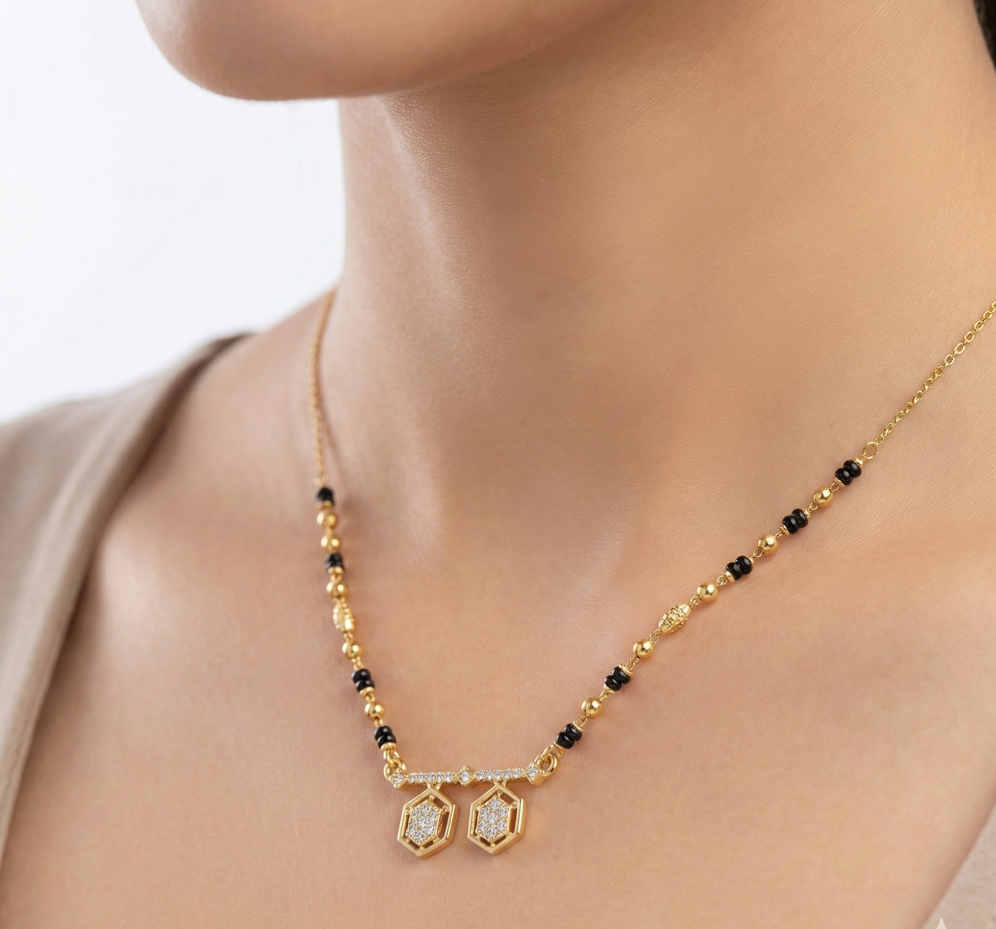 Gold necklace with black beads and diamond pendants on a model