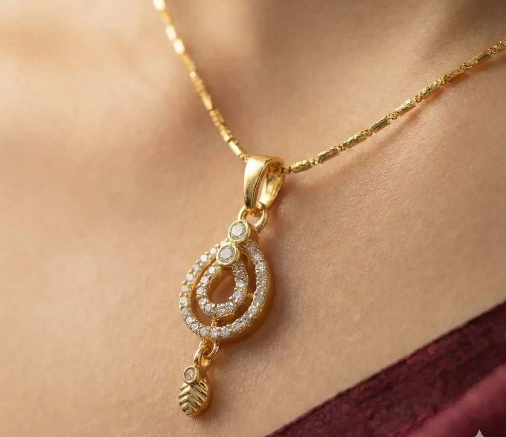 Gold necklace with a decorative pendant on a person's neck