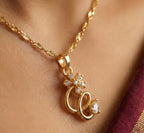 Gold necklace with a floral pendant on a person's neck