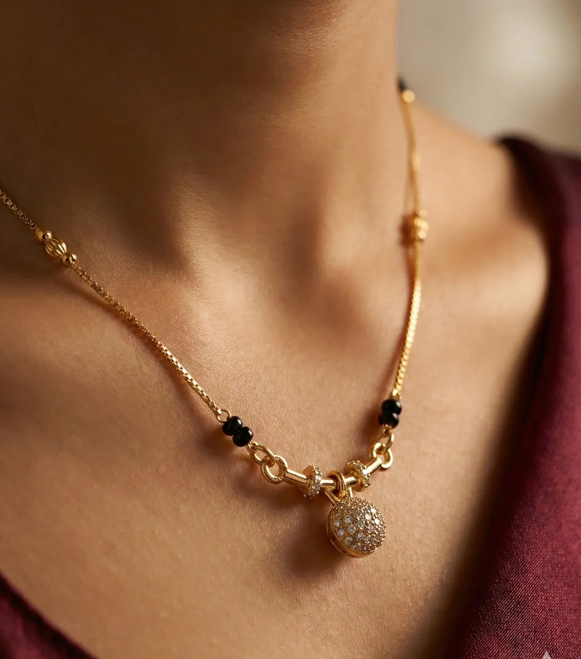 Gold necklace with a pendant on a person's neck