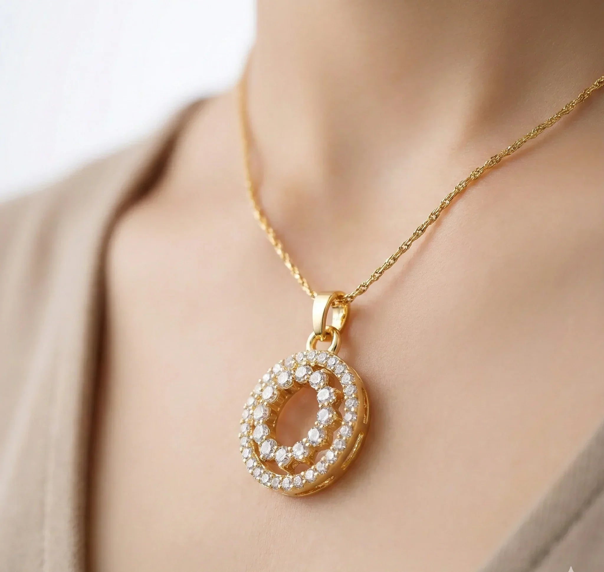Gold necklace with a diamond pendant on a neutral background