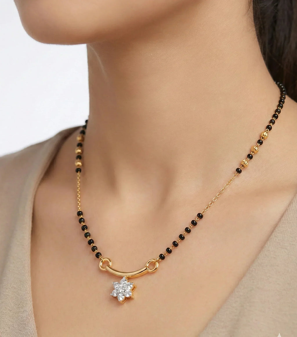 Gold necklace with black beads and a star-shaped pendant on a model