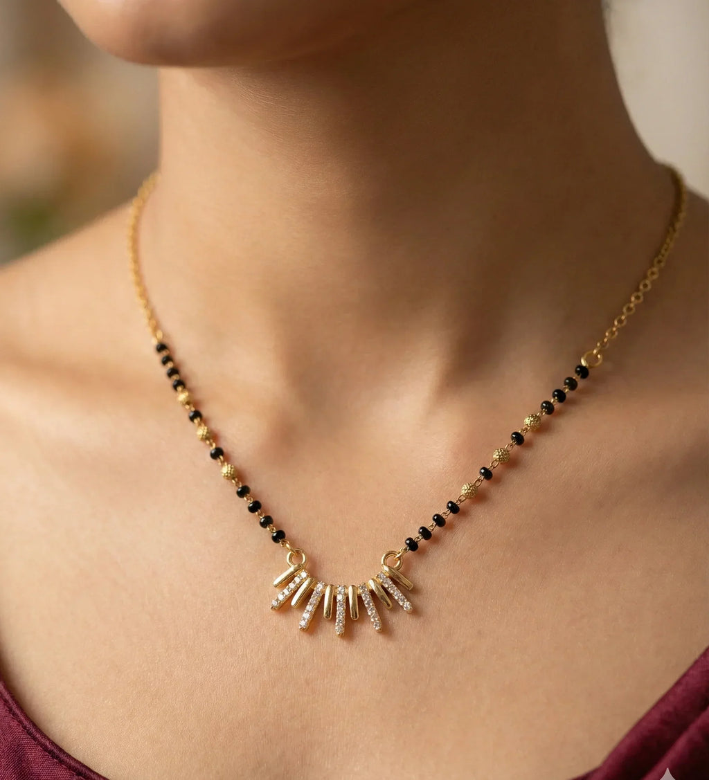 Necklace with black and gold beads on a blurred background