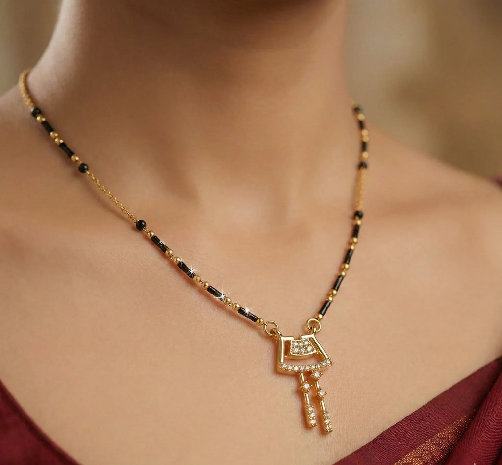 Gold necklace with a key pendant on a blurred background