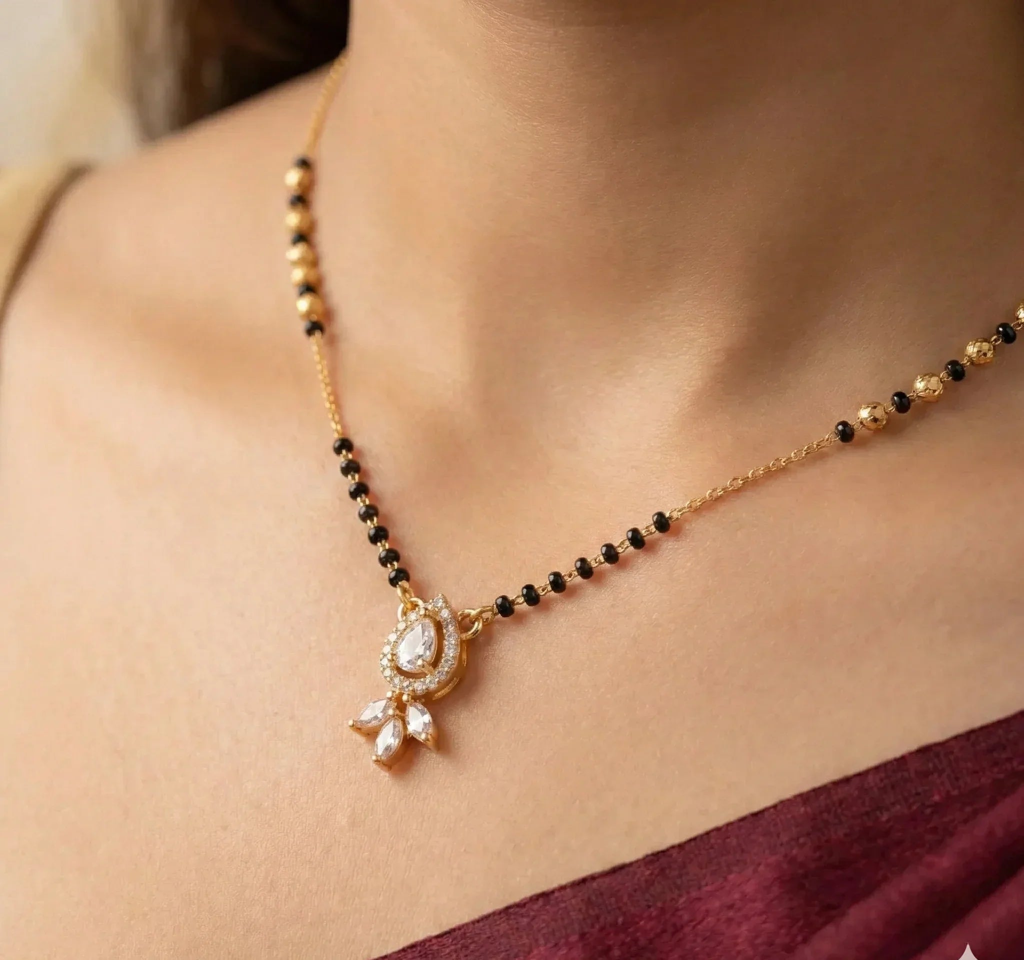 Necklace with a pendant on a person wearing a maroon saree