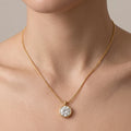 Gold necklace with a diamond pendant on a neutral background
