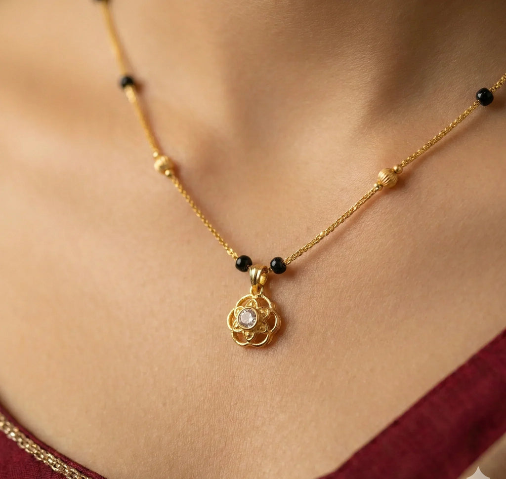 Gold necklace with a pendant on a person wearing a red garment