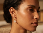 Close-up of a woman wearing a gold earring with a blurred background