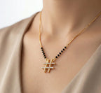 Necklace with gold and black beads on a neutral background