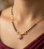 Necklace with a star-shaped pendant worn by a person in a burgundy top.