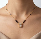 Necklace with a pendant on a person's neck against a neutral background