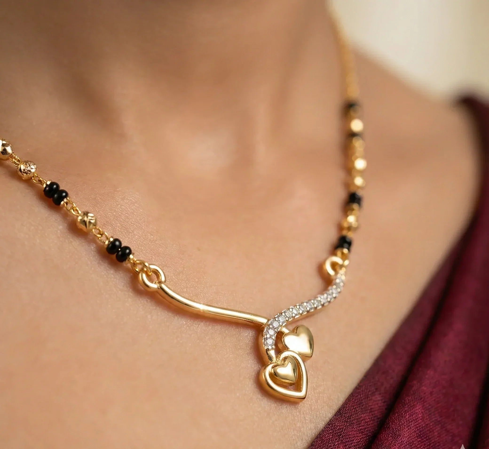 Gold necklace with heart pendants on a blurred background