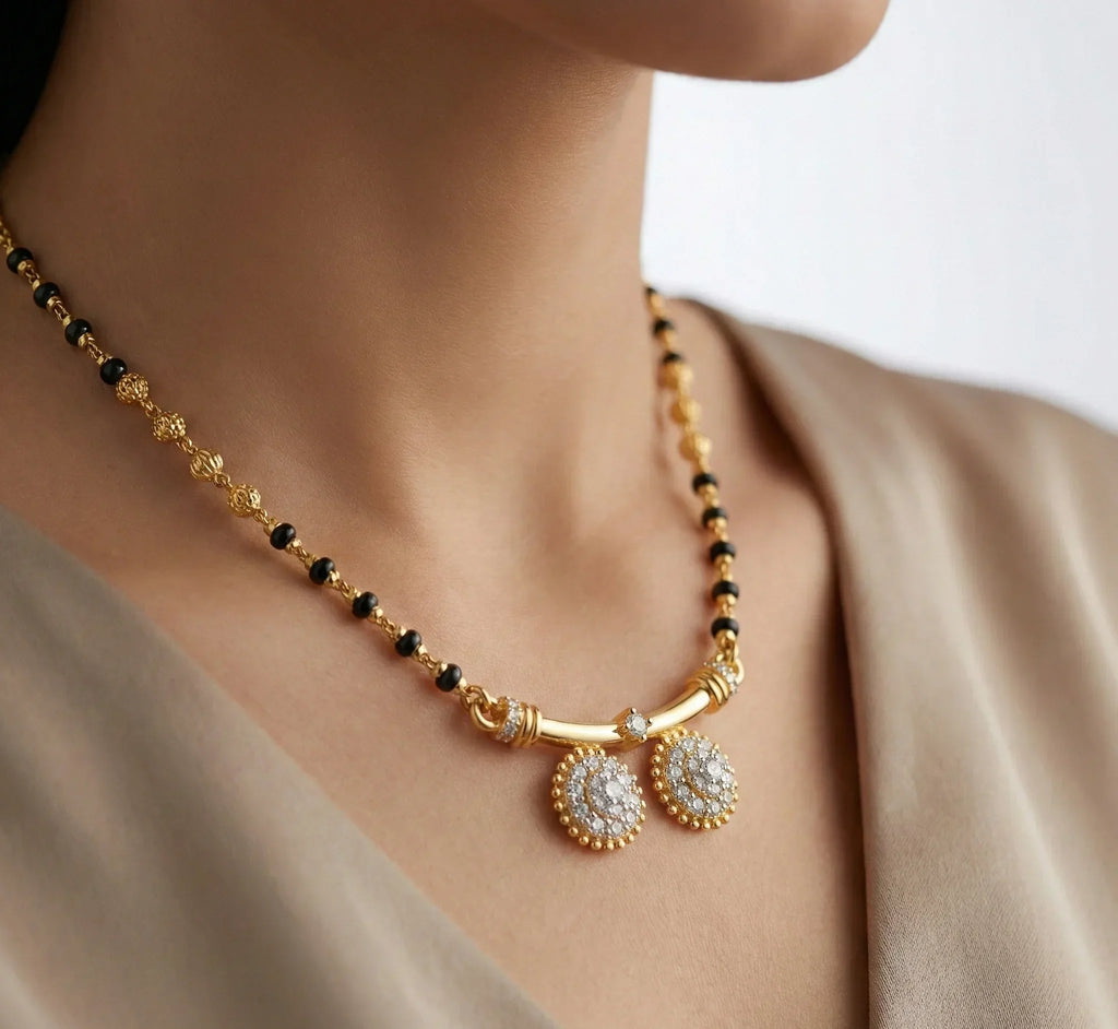 Gold necklace with black beads and decorative elements on a neutral background
