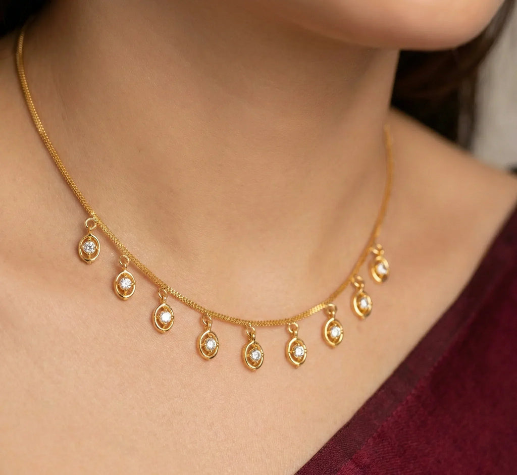 Gold necklace with dangling beads worn by a person