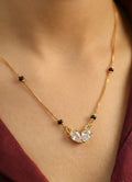 Gold necklace with a heart-shaped pendant on a person's neck