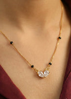 Gold necklace with a heart-shaped pendant on a person's neck