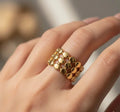 Gold ring on a person's finger with a blurred background