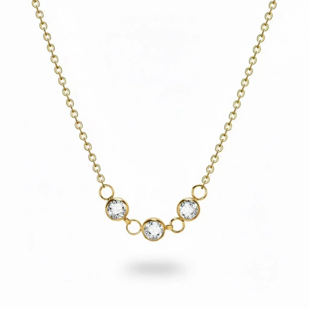 Gold necklace with three crystal pendants on a white background