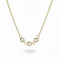 Gold necklace with three crystal pendants on a white background