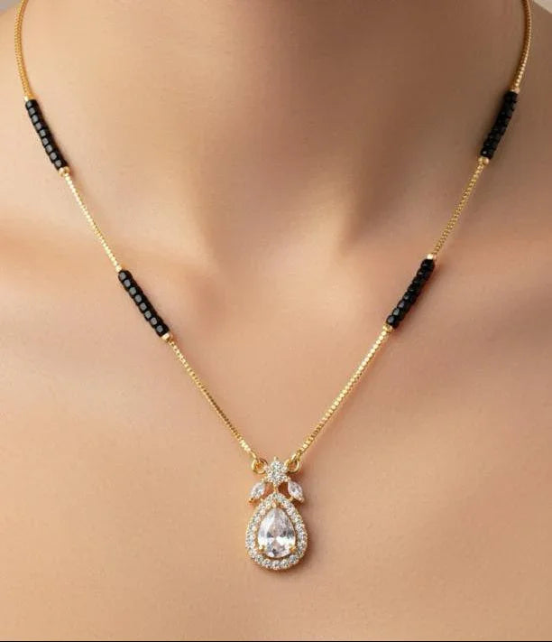 Gold necklace with a pendant on a model against a neutral background