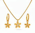 Gold flower-shaped jewelry set with necklace, earrings, and hoop earrings on a white background