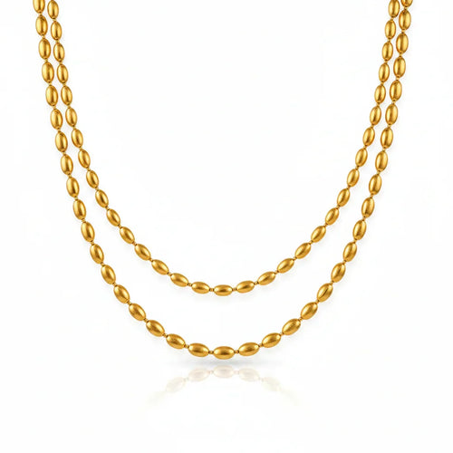Gold beaded necklace on a white background